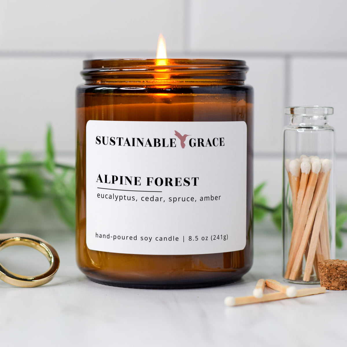 alpine forest blue spruce scented soy candle from sustainable grace in an amber colored jar 
