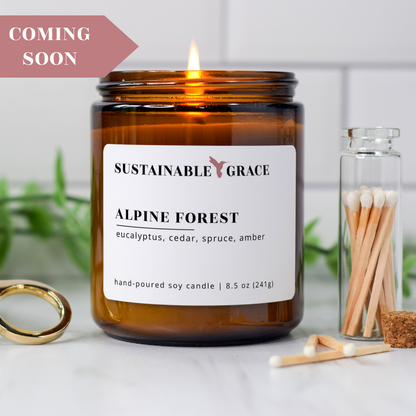 alpine forest blue spruce scented soy candle from sustainable grace in an amber colored jar 