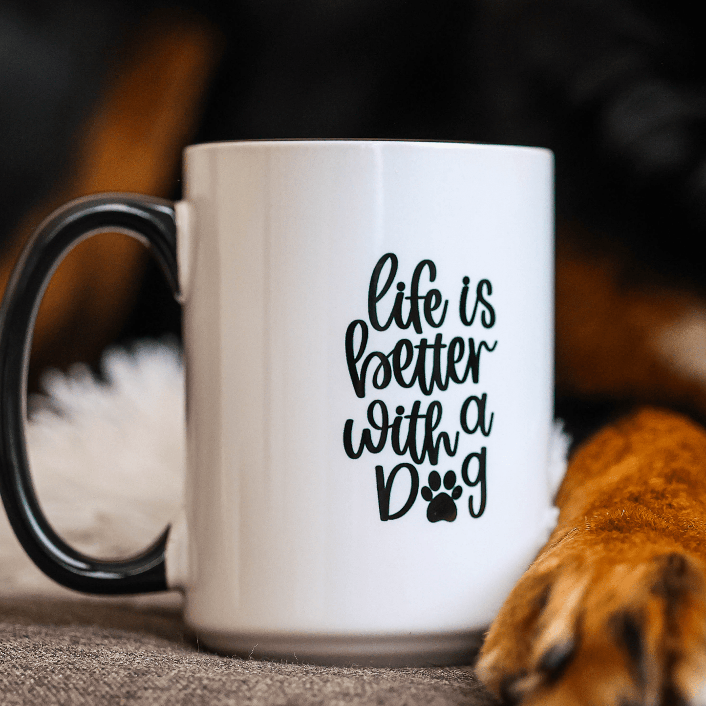 white and black coffee mug with life is better with a dog saying